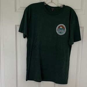 Green short sleeved surf vibe tee featuring the Mavericks Wave in Half Moon Bay.